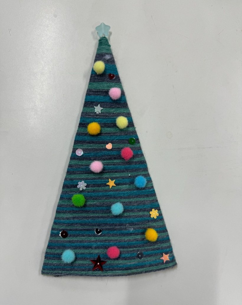 毛糸ツリーに飾りをつけている